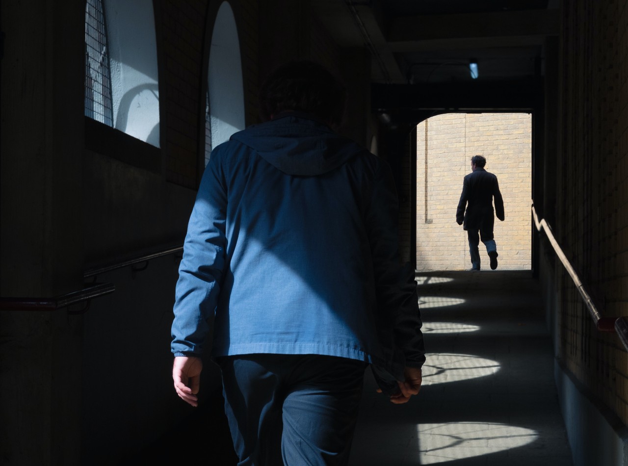 Man in blue jacket spying.